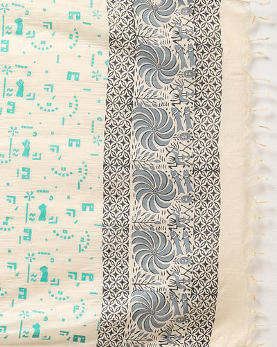 Off white and slate blue Katan silk unstitched suit set hand block printed with stylised swirls and fish motifs in an asymmetric repeat, with teal and charcoal grey accents and fringed edges.