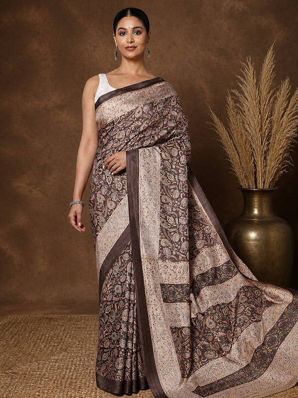 Dark brown printed saree in a fine paisley and floral print flecked with cream, mustard and pink, with a narrow brown border.